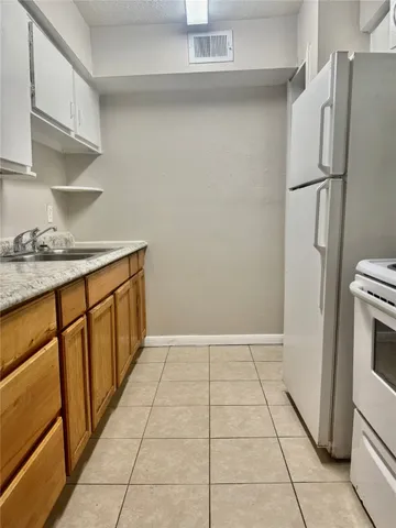 a kitchen with granite countertop white cabinets and a sink