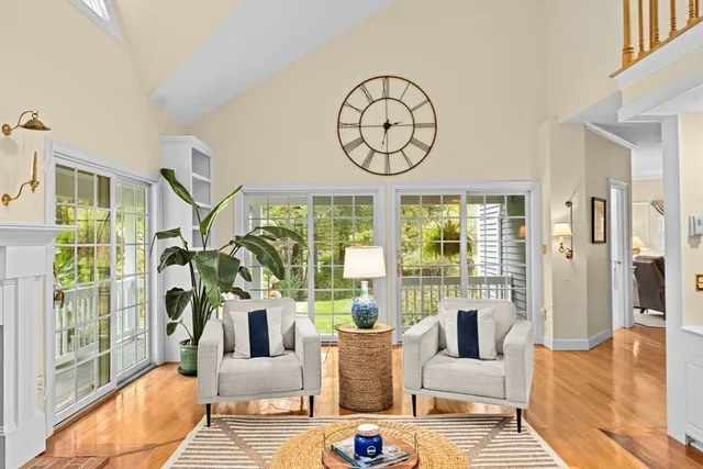 a living room with furniture a large window and a chandelier