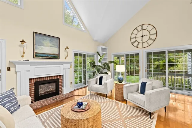a living room with furniture a fireplace and a floor to ceiling window