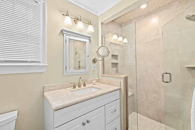 a bathroom with a granite countertop sink a mirror and a shower