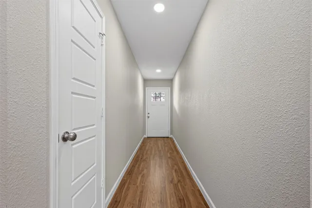 a view of a hallway with wooden floor and entryway