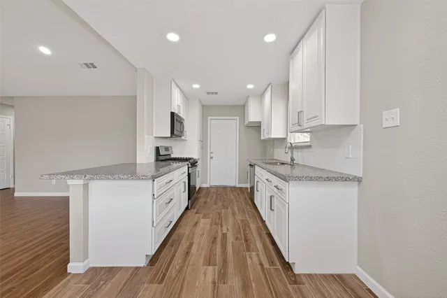 a kitchen with granite countertop a sink and cabinets