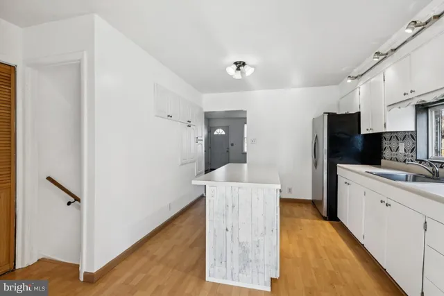 a kitchen with a sink a refrigerator and cabinets