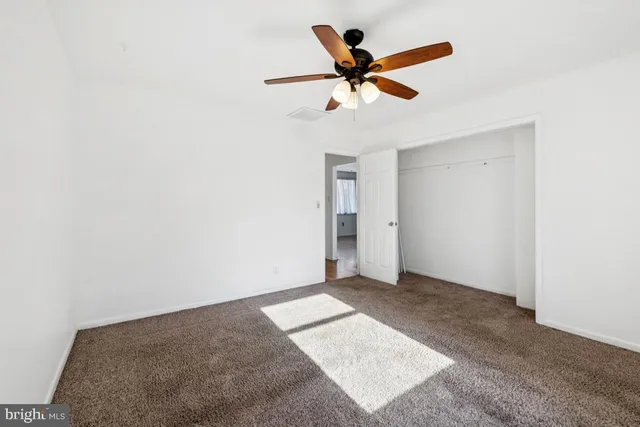 a view of a hallway with a ceiling fan