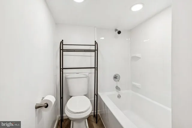 a bathroom with a granite countertop toilet a sink and bathtub
