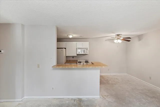 an empty room with a window and a fan