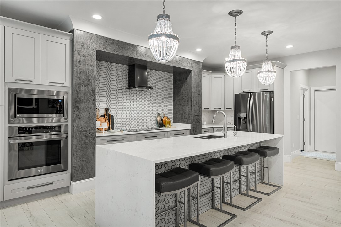 140 Turnberry Road Anderson, SC 29621 - Photo 10 of 44 This modern kitchen features a spacious island, built-in appliances, and elegant lighting fixtures.