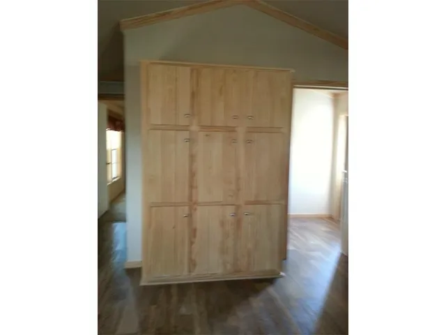 a view of a room with wooden floor and cabinet