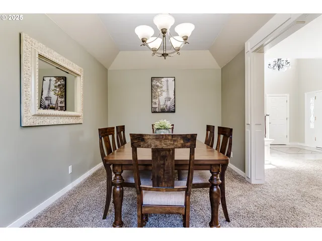 a kitchen with kitchen island a dining table chairs and white cabinets