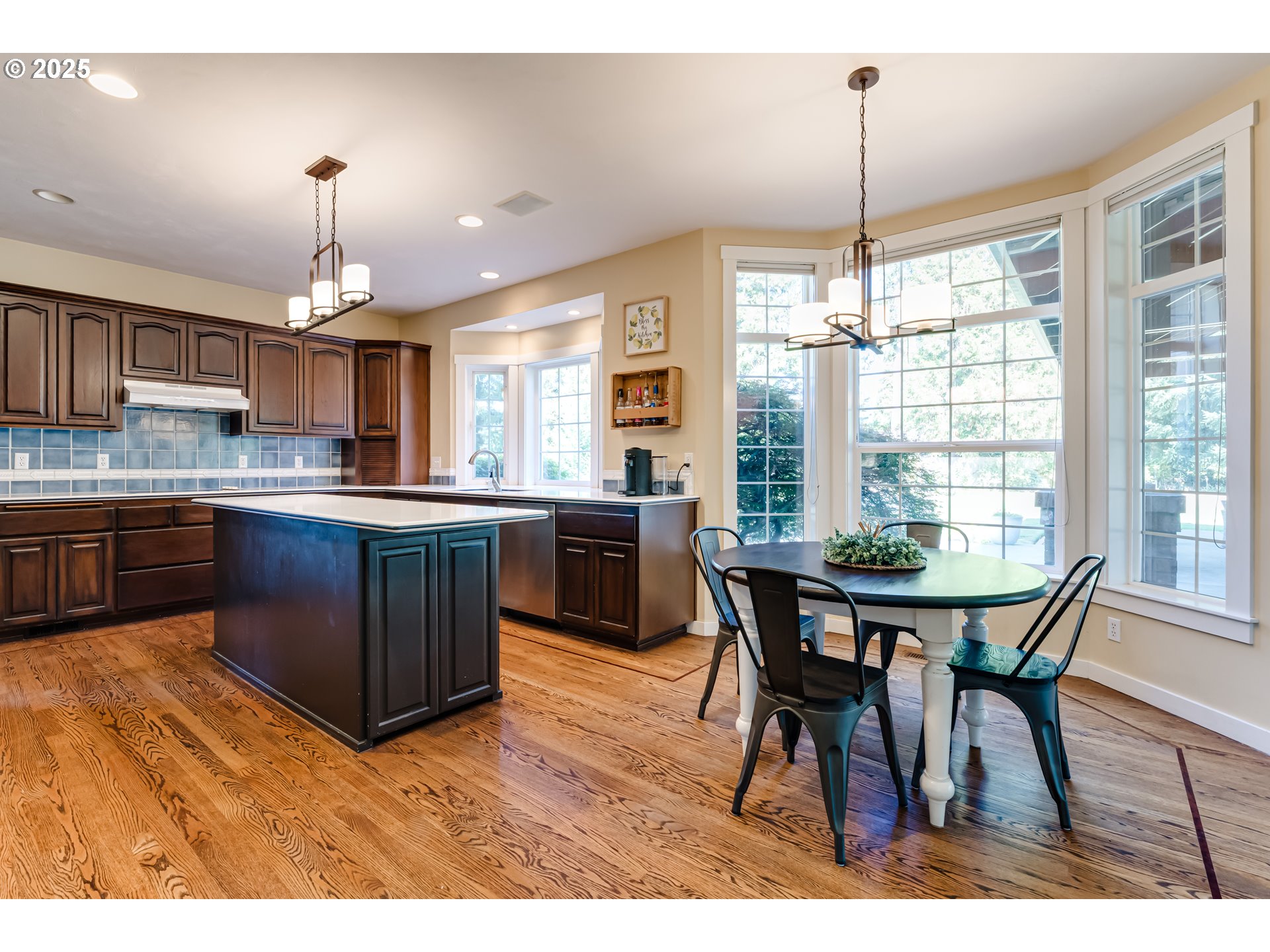 39125 Easton Lane Springfield, OR 97478 - Photo 12 of 47 a kitchen with kitchen island a dining table chairs and white cabinets