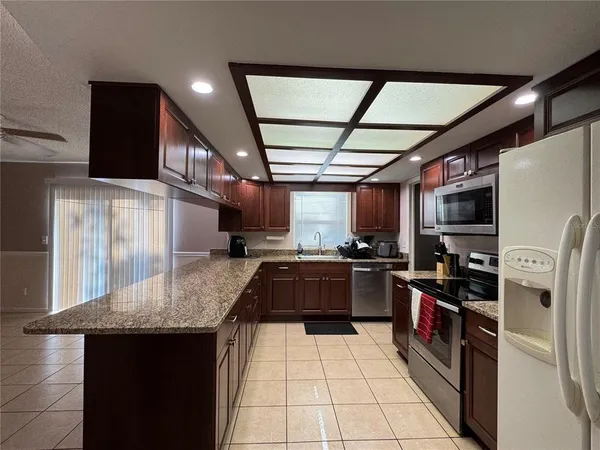 a kitchen with stainless steel appliances granite countertop a sink stove and refrigerator