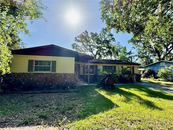 a view of house with yard and outdoor seating