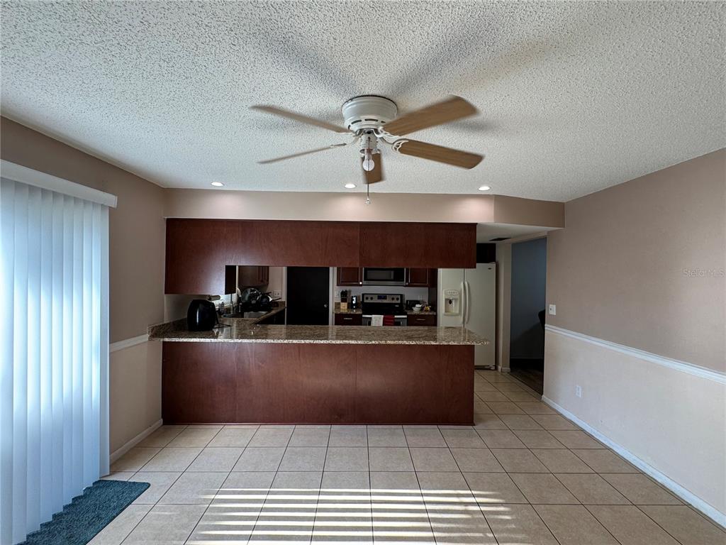1703 North Taylor Road Brandon, FL 33510 - Photo 25 of 32 a living room with stainless steel appliances kitchen island granite countertop a refrigerator a stove and a sink