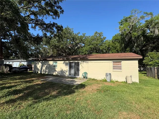a view of a house with backyard and a tree