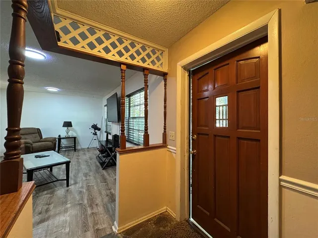 a view of an entryway with wooden floor and a livingroom