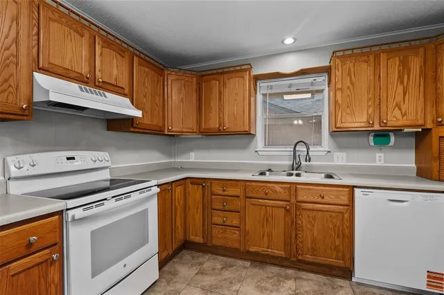 a kitchen with stainless steel appliances granite countertop a sink stove and cabinets