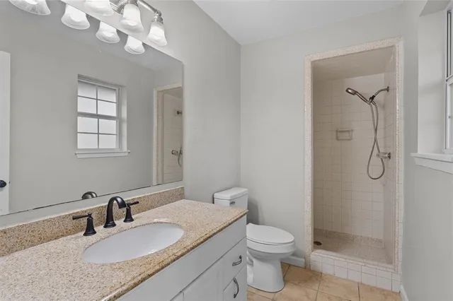 a bathroom with a granite countertop sink a toilet and a mirror