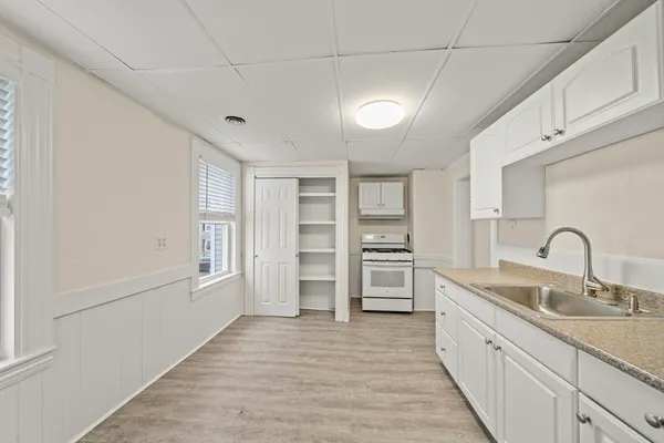 a kitchen with white cabinets and sink