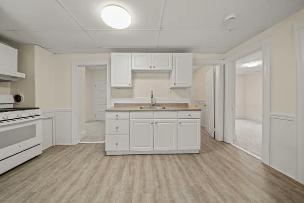 a kitchen with a sink cabinets and wooden floor