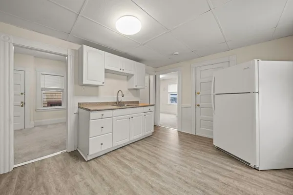a kitchen with white cabinets and white appliances