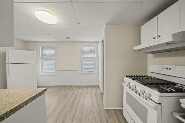 a stove top oven sitting inside of a kitchen