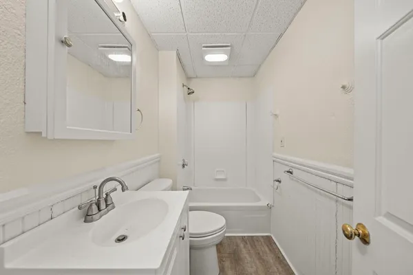 a bathroom with a sink a toilet and shower