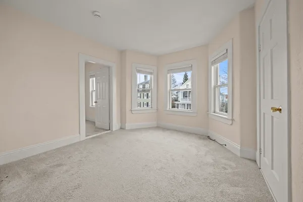an empty room with windows and closet