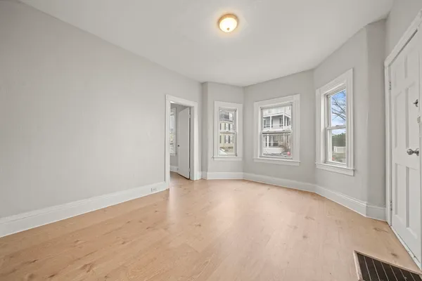 an empty room with windows and closet