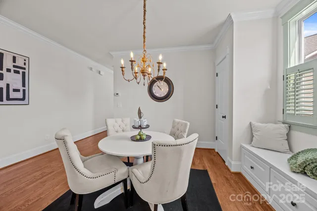 a dining room with furniture a chandelier and wooden floor