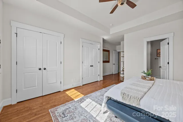 a bedroom with a bed and a chandelier fan