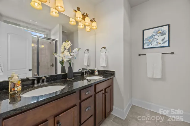 a bathroom with a granite countertop sink a large mirror and a shower