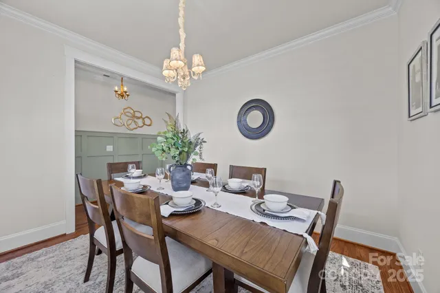 a view of a dining room with furniture a chandelier and wooden floor