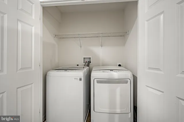 an empty room with windows and chandelier fan