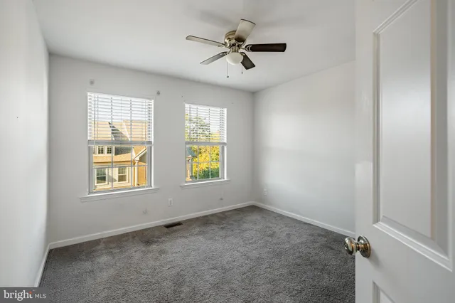 an empty room with closet and windows