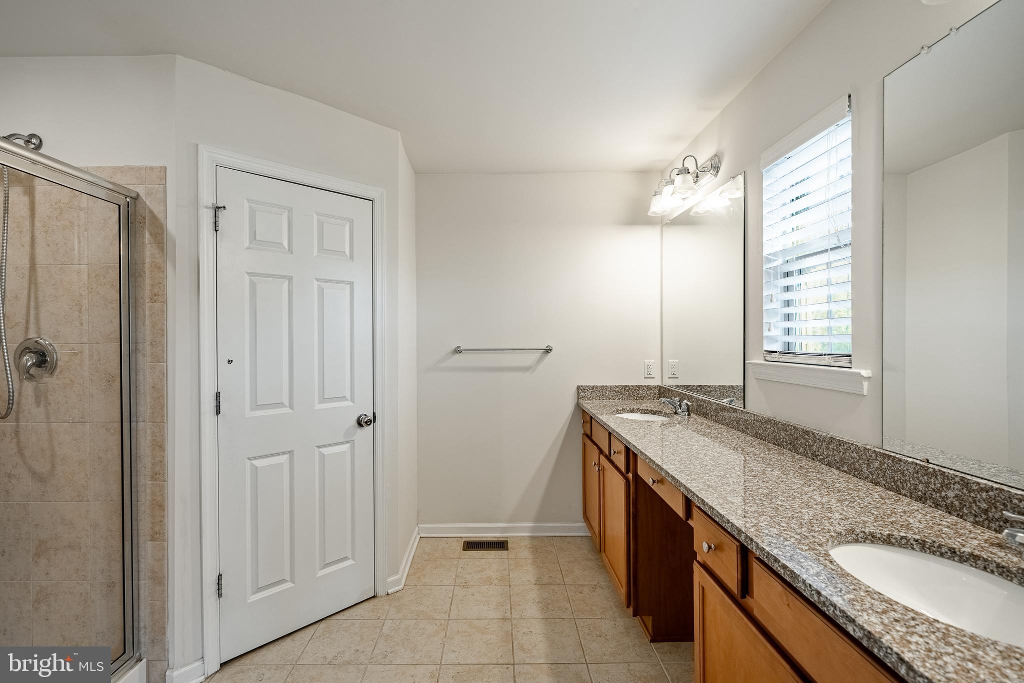 33 Addison Lane Malvern, PA 19355 - Photo 25 of 32 a bathroom with a granite countertop sink a mirror and a bathtub