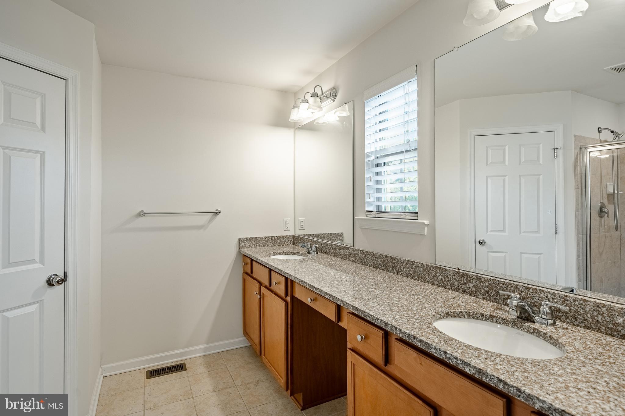 33 Addison Lane Malvern, PA 19355 - Photo 26 of 32 a bathroom with a granite countertop sink and a mirror