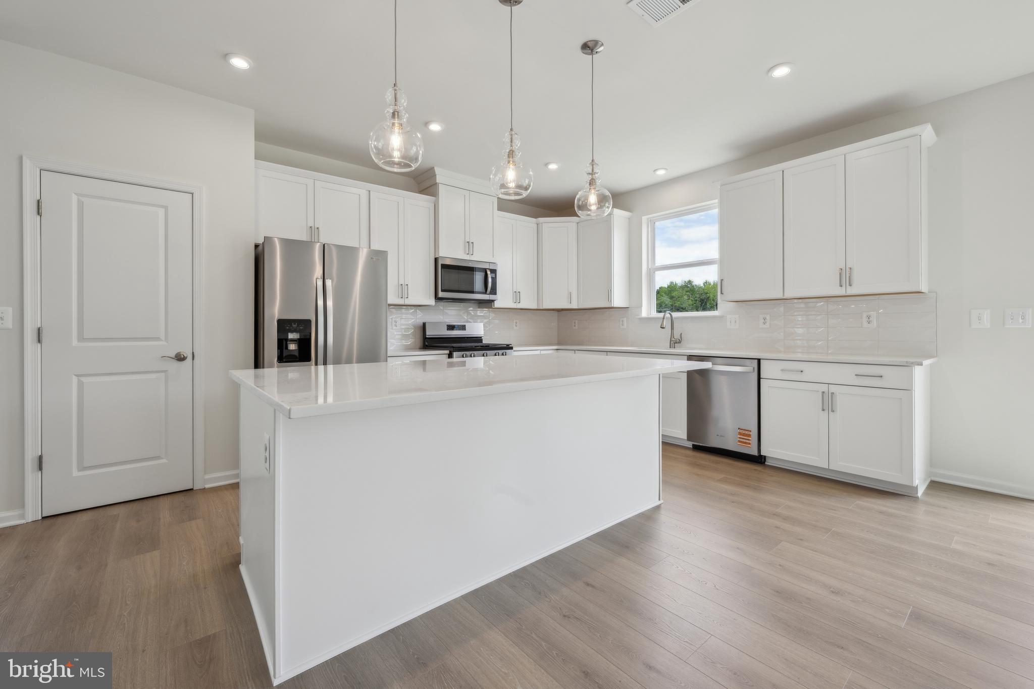 24755 Michael Isler Avenue Millsboro, DE 19966 - Photo 5 of 14 a kitchen with stainless steel appliances a refrigerator sink and microwave