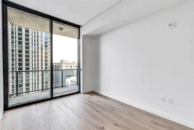 a view of a big room with wooden floor and windows