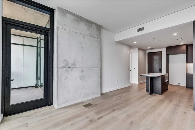 a view of a hallway with wooden floor and cabinet