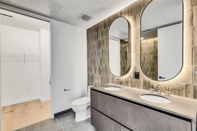 a bathroom with a granite countertop toilet a sink and a mirror