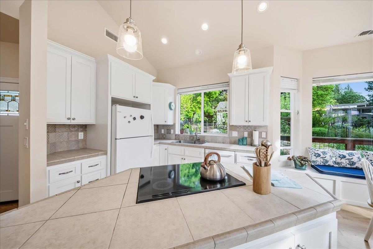 709 Cole Road Meadow Vista, CA 95722 - Photo 5 of 57 a kitchen with stainless steel appliances kitchen island granite countertop a refrigerator a sink dishwasher and white cabinets next to a window