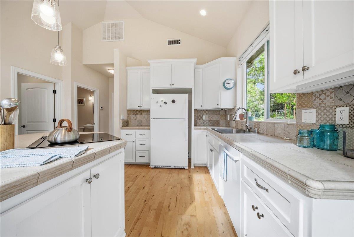 709 Cole Road Meadow Vista, CA 95722 - Photo 6 of 57 a kitchen with white cabinets and white appliances