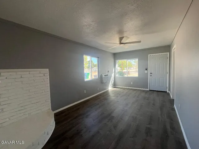 a view of empty room with window and wooden floor