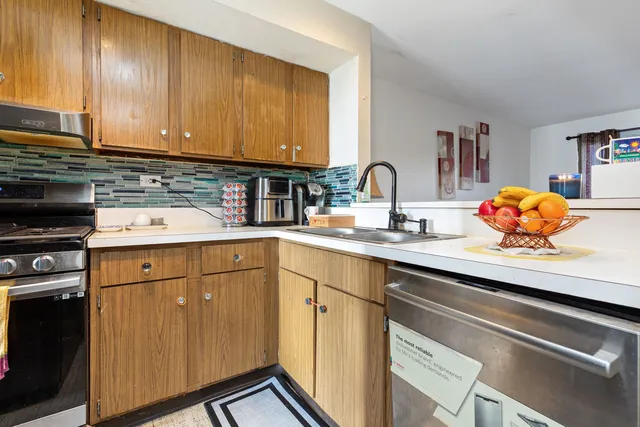a kitchen with stainless steel appliances granite countertop a sink stove and cabinets