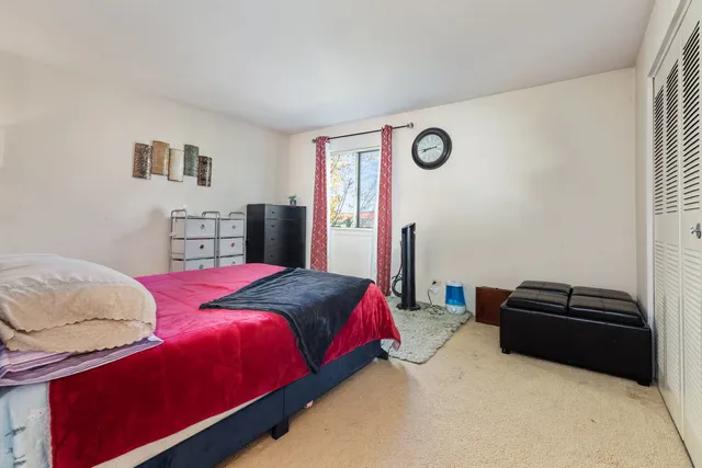 a bedroom with a bed and a refrigerator