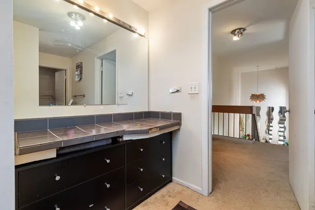 a bathroom with a granite countertop sink and a mirror