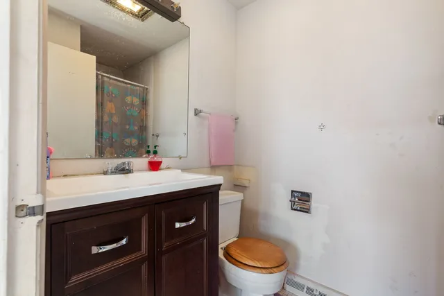 a bathroom with a sink vanity mirror and toilet