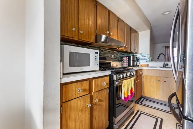a kitchen with stainless steel appliances granite countertop a stove a sink and a microwave