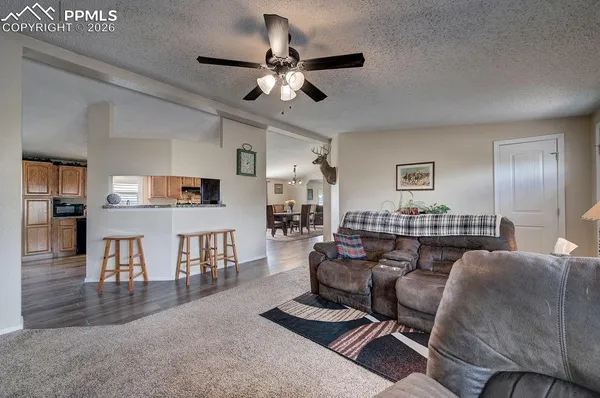 a living room with furniture a flat screen tv and kitchen view