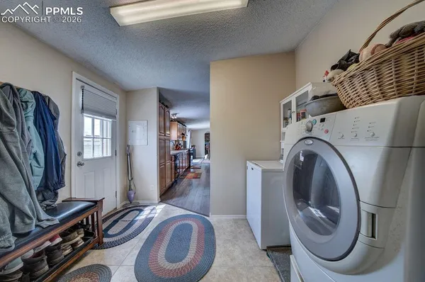 a bathroom with a toilet mirror washing machine and a sink
